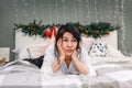 Senior asian woman relax on bed with xmas lights, attractive elderly sad lady in bedroom at home at christmas