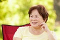 Senior Asian woman sitting outdoors Royalty Free Stock Photo