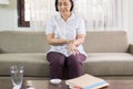 Senior asian woman suffering with parkinson`s disease symptoms on hands