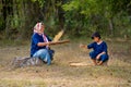 Senior Asian woman with traditional clothes winnow rice using basketry and little girl stay beside and also work with rice