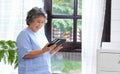 Senior asian woman using digital tablet computer at home background, Retirement asian woman and digital tablet standing by home Royalty Free Stock Photo