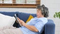 Senior asian woman using digital tablet computer, Retirement asian woman and digital tablet while lying on sofa at home living Royalty Free Stock Photo