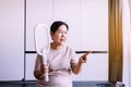 Senior asian woman using mosquito swatter at home,Elderly women with mosquito electric net racket