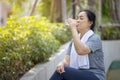 Senior athletic woman drinks water from a bottle after running in the park Royalty Free Stock Photo