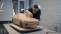 Automotive designer sculpts the prototype model of the car using sculpting tools