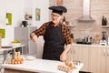 Senior baker in home kitchen putting wheat