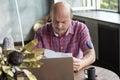 Senior bald man paying bills with his laptop Royalty Free Stock Photo