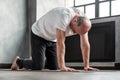 Senior bald yogi men practices yoga asana marjariasana or cat-cow pose