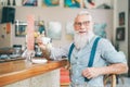 Senior bearded man drinking coffee sitting bar counter - Happy mature male having fun enjoying time outdoor Royalty Free Stock Photo