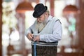 Senior bearded man measuring his belly with tape measure.