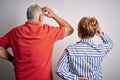 Senior beautiful couple standing together over isolated white background Backwards thinking about doubt with hand on head Royalty Free Stock Photo