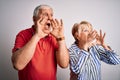 Senior beautiful couple standing together over isolated white background Shouting angry out loud with hands over mouth Royalty Free Stock Photo