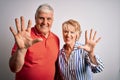 Senior beautiful couple standing together over isolated white background showing and pointing up with fingers number ten while Royalty Free Stock Photo
