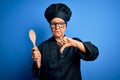 Senior beautiful grey-haired chef woman wearing cooker uniform and hat holding wooden spoon with angry face, negative sign showing Royalty Free Stock Photo