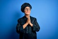 Senior beautiful grey-haired chef woman wearing cooker uniform and hat over blue background begging and praying with hands Royalty Free Stock Photo