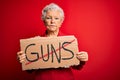 Senior beautiful grey-haired woman holding banner with prohibited guns message with a confident expression on smart face thinking Royalty Free Stock Photo