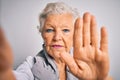 Senior beautiful grey-haired woman making selfie by camera over isolated white background with open hand doing stop sign with Royalty Free Stock Photo