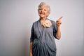 Senior beautiful grey-haired woman wearing casual dress standing over white background with a big smile on face, pointing with Royalty Free Stock Photo