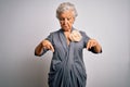 Senior beautiful grey-haired woman wearing casual dress standing over white background Pointing down looking sad and upset, Royalty Free Stock Photo