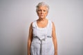 Senior beautiful grey-haired woman wearing casual summer dress over white background depressed and worry for distress, crying Royalty Free Stock Photo