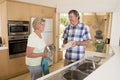 Senior beautiful middle age couple around 70 years old smiling happy at home kitchen washing the dishes looking sweet together Royalty Free Stock Photo