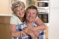 Senior beautiful middle age couple around 70 years old smiling happy together at home kitchen looking sweet in lifetime husband an