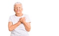 Senior beautiful woman with blue eyes and grey hair wearing casual white tshirt smiling with hands on chest with closed eyes and Royalty Free Stock Photo