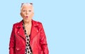 Senior beautiful woman with blue eyes and grey hair wearing a modern style with a red leather jacket scared and amazed with open