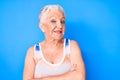 Senior beautiful woman with blue eyes and grey hair wearing sporty sleeveless shirt happy face smiling with crossed arms looking Royalty Free Stock Photo