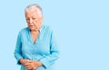 Senior beautiful woman with blue eyes and grey hair wearing summer dress with hand on stomach because indigestion, painful illness Royalty Free Stock Photo