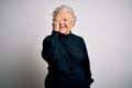 Senior beautiful woman wearing casual black sweater standing over isolated white background covering one eye with hand, confident Royalty Free Stock Photo