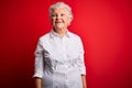 Senior beautiful woman wearing elegant shirt standing over isolated red background smiling looking to the side and staring away Royalty Free Stock Photo