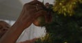 Senior biracial woman hanging ornaments on Christmas tree Royalty Free Stock Photo