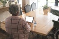 Senior biracial woman having video call at home with doctor on tablet with copy space Royalty Free Stock Photo