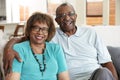 Senior African American couple sitting at home, smiling to camera, close up