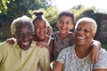 Senior black couple sitting outdoors with grandchildren