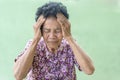 Senior black-haired woman touching head with hand with painful expression because of headache. Mature woman suffering from