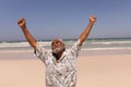 Senior black man with arms outstretched standing on beach Royalty Free Stock Photo