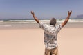 Senior black man with arms outstretched standing on beach Royalty Free Stock Photo