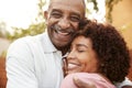 Senior African American man and his middle aged daughter embracing, close up