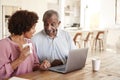 Senior African American  man and his middle aged daughter using a laptop together at home, close up Royalty Free Stock Photo