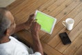 Senior African American  man sitting at table using tablet computer, elevated over shoulder view Royalty Free Stock Photo