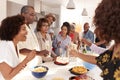 Senior African American  woman blowing out the candle on birthday cake during a celebration with her family Royalty Free Stock Photo