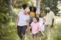 Senior black woman walking with grandson and family in woods