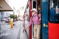 Senior blind man with white cane getting out of public transport in city. Royalty Free Stock Photo