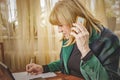 Elderly lady writing down orders, work from home Royalty Free Stock Photo