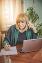 Elderly lady writing down orders, work from home Royalty Free Stock Photo