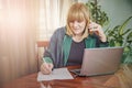 Elderly lady writing down orders, work from home Royalty Free Stock Photo