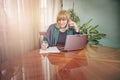 Elderly lady writing down orders, work from home Royalty Free Stock Photo