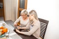 A senior blonde woman learns to use a tablet computer. She wants to learn how to buy cat food online. But she also wants to know Royalty Free Stock Photo